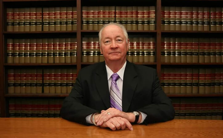 Keith Galliher in front of bookcase